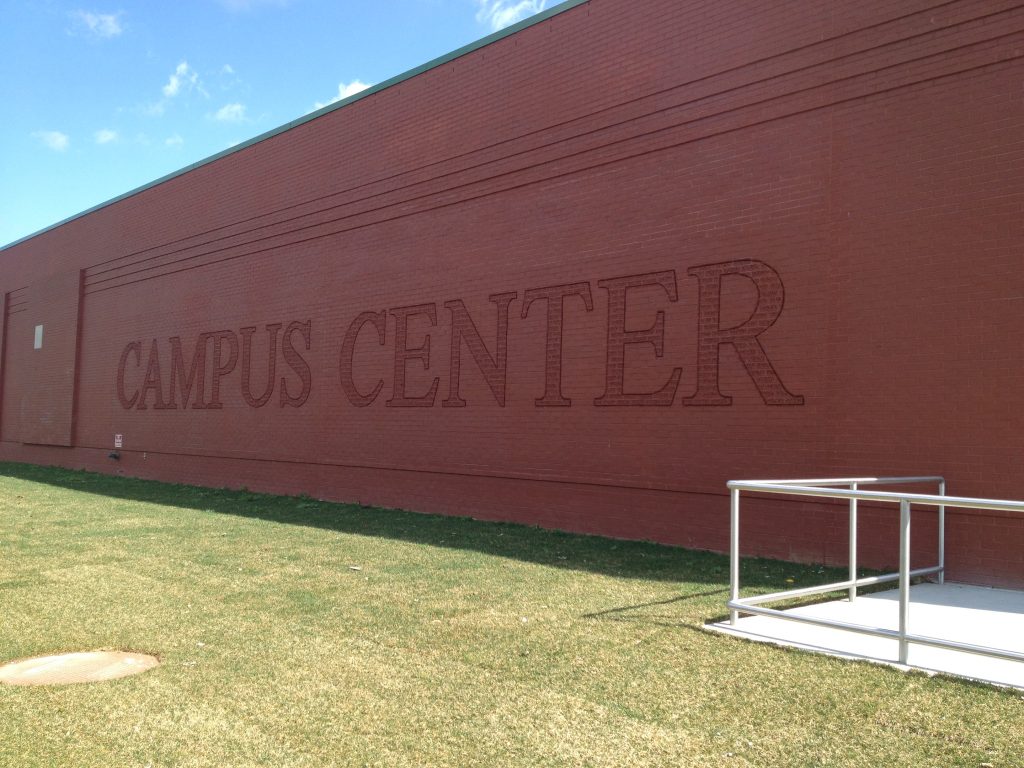 Brick exterior wall of the Campus Center with CAMPUS CENTER lettering and an accessibility ramp at the corner.