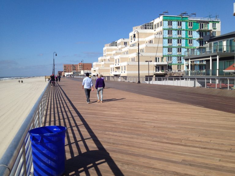 Walkers passing buildings still under post-Sandy repairs along the Long Beach boardwalk.