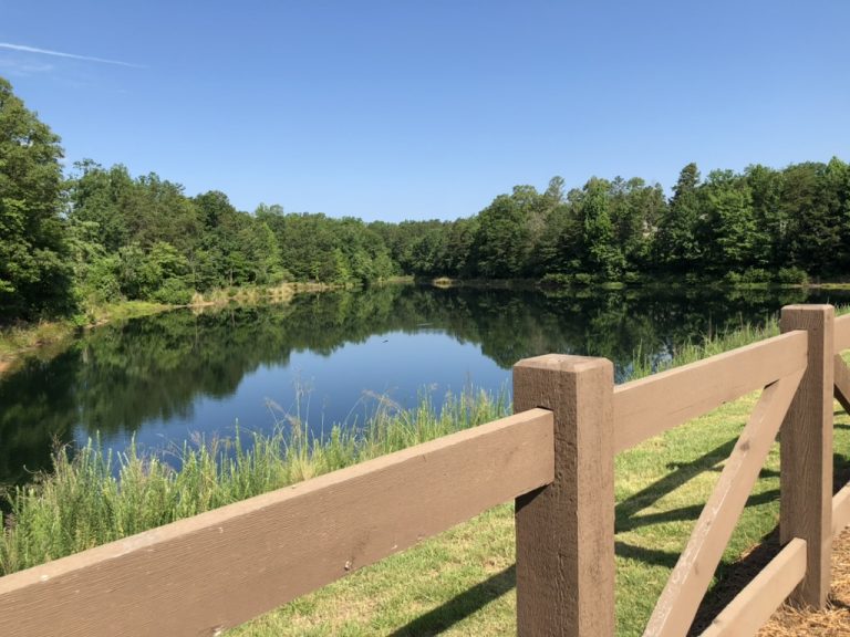 A split-rail fence frames a quiet view of Lake Wylie.