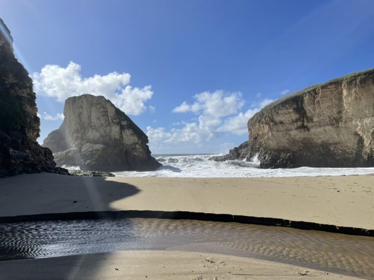 Shark Fin Rock seen from the sand at low tide