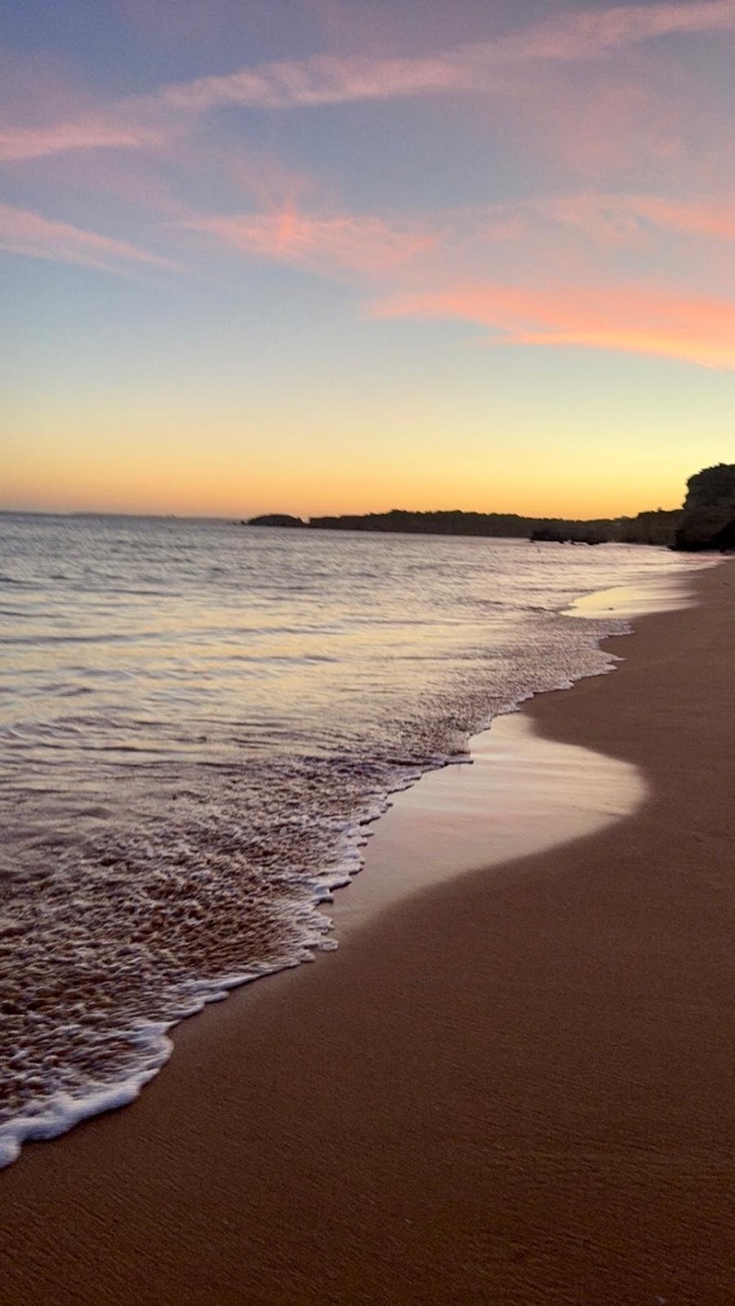 Pink skies and quiet waves at sundown