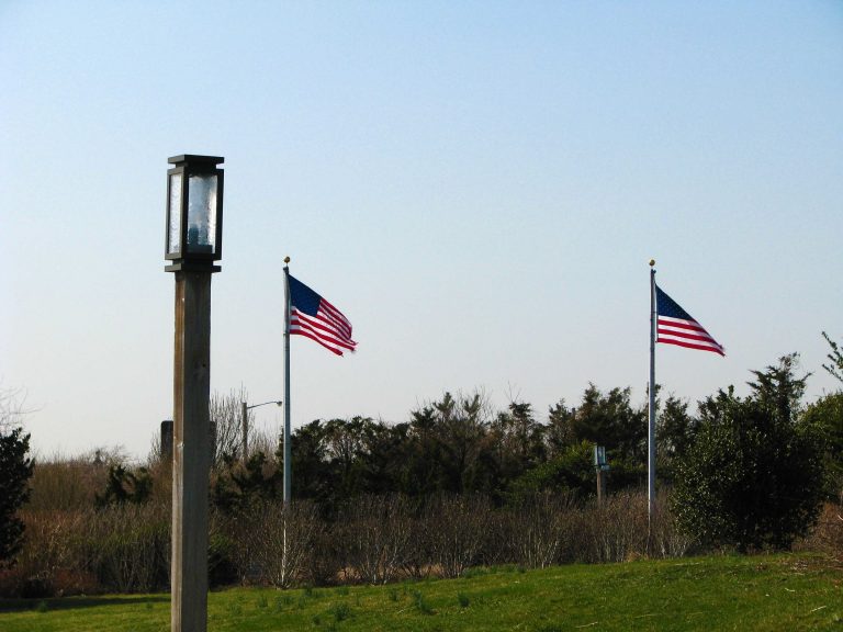 Flagpoles and an old wooden lamppost catching late winter light.