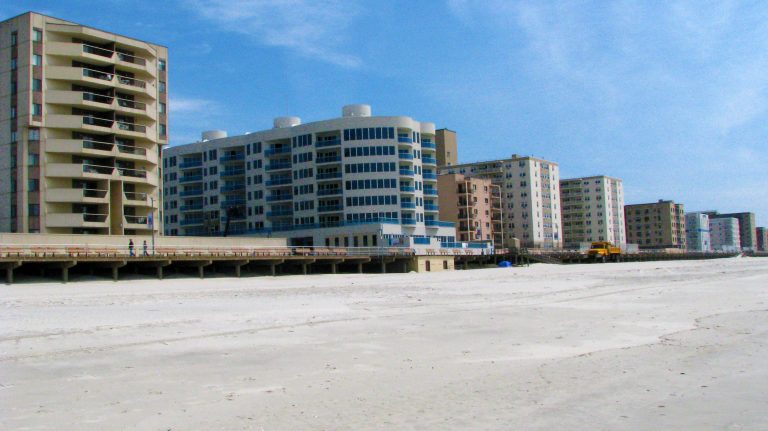 A long row of beachfront condos seen from the sand.