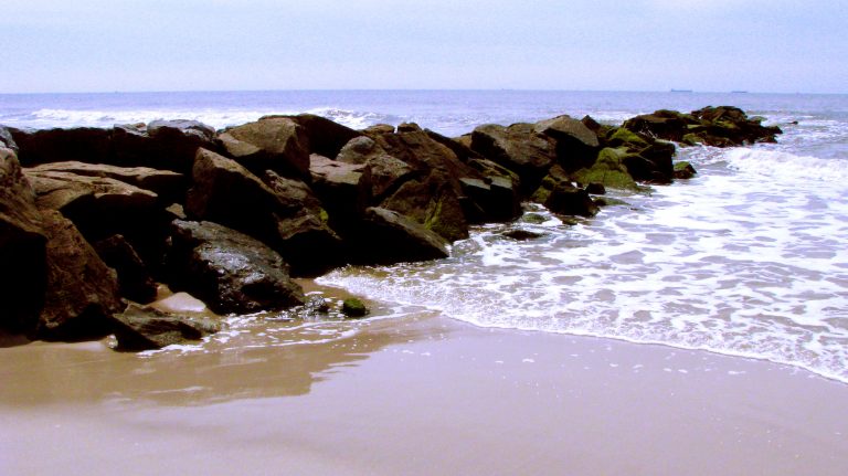 Waves curling around the jetty rocks at Long Beach.