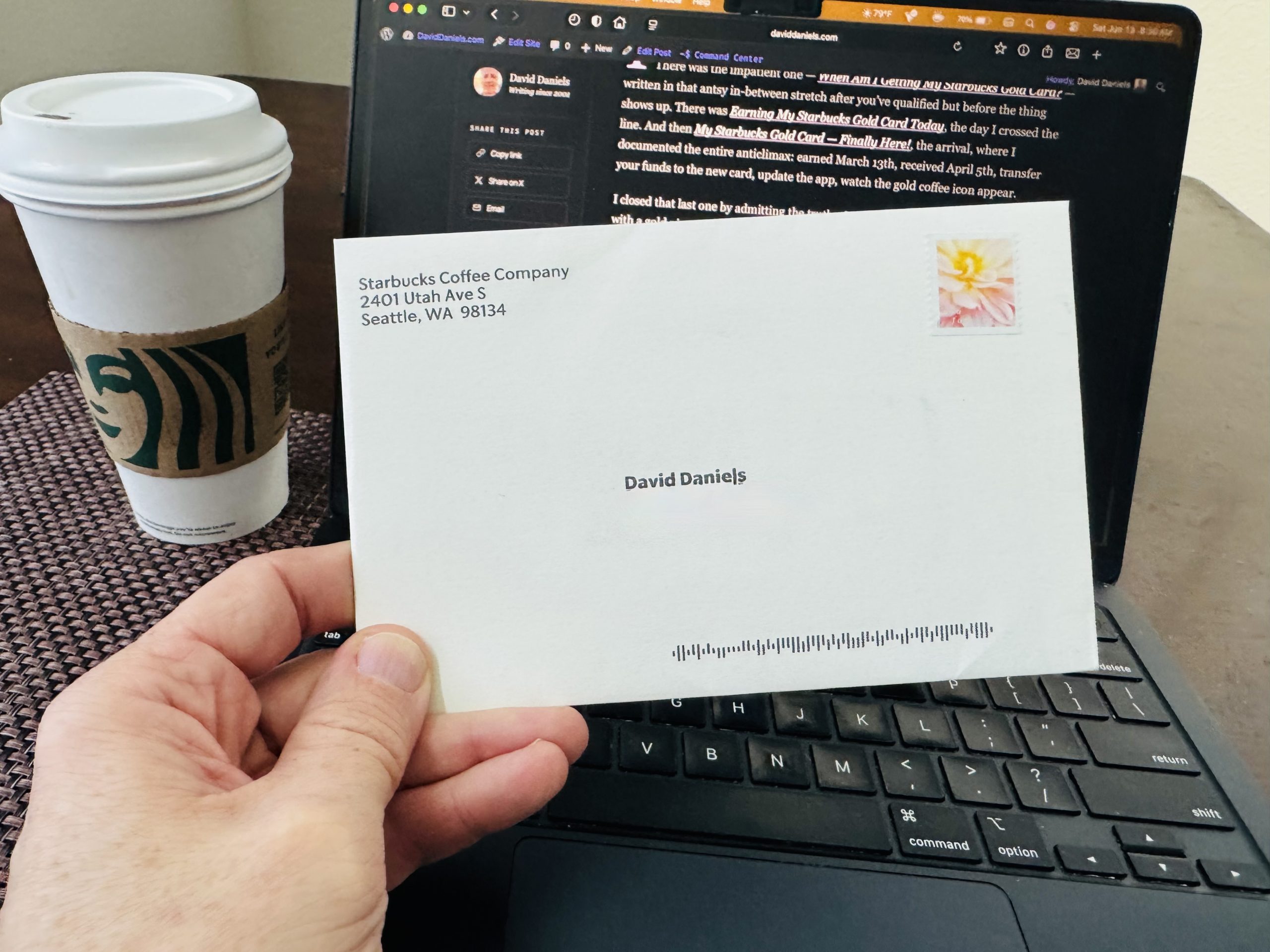 Envelope from Starbucks Coffee Company in Seattle addressed to David Daniels, with a coffee cup and laptop behind it