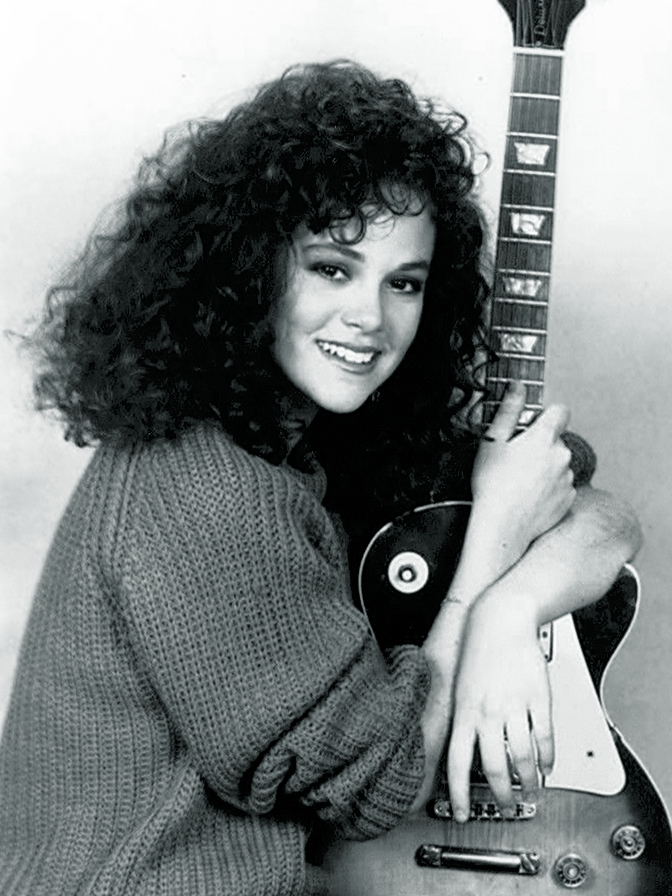 Rebecca Schaeffer smiling and holding an acoustic guitar, circa 1986-88